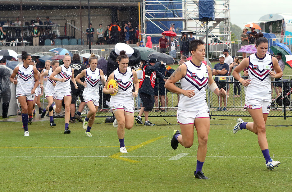 AFLW 2018 Rd 04 - Brisbane Lions v Fremantle BRISBANE, AUSTRALIA - FEBRUARY 24: The Freemantle team run out during the round four AFLW match between the Brisbane Lions and the Fremantle Dockers at South Pine Sports Complex on February 24, 2018 in Brisbane, Australia. (Photo by Jono Searle/Getty Images/AFL Media)